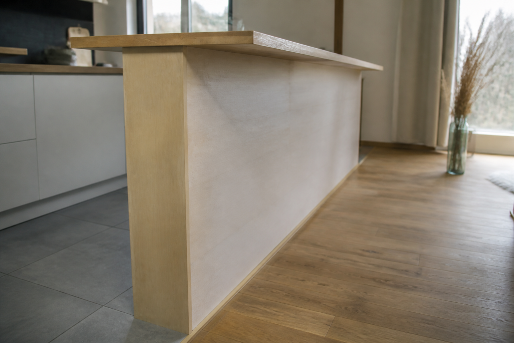 Bar en bois clair separant carrelage gris et parquet