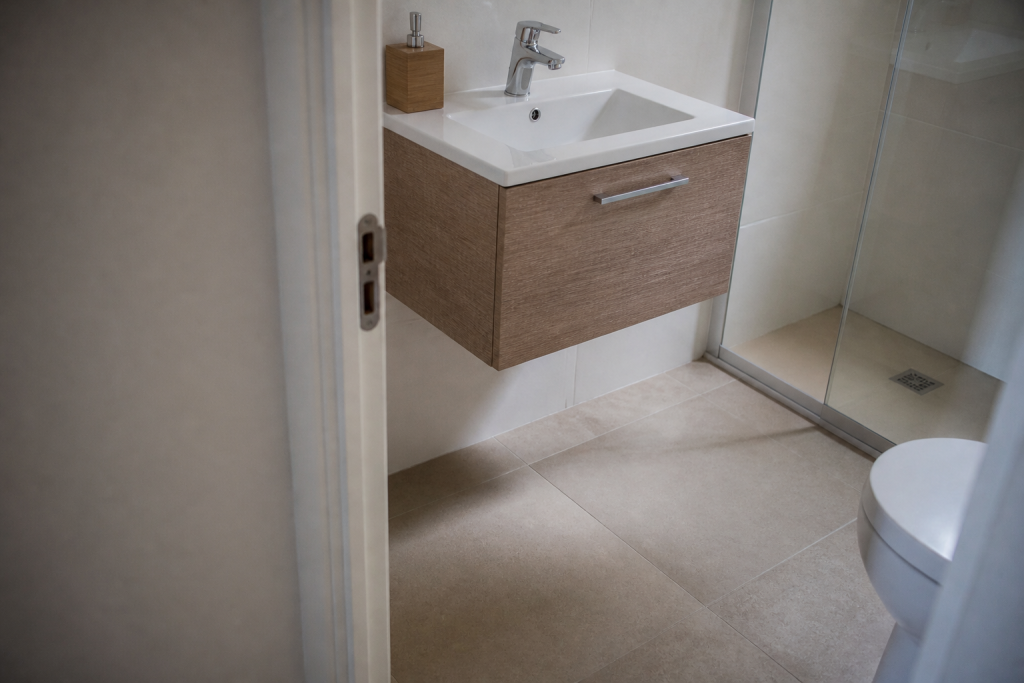 Petite salle de bain, vasque suspendue, sol visible