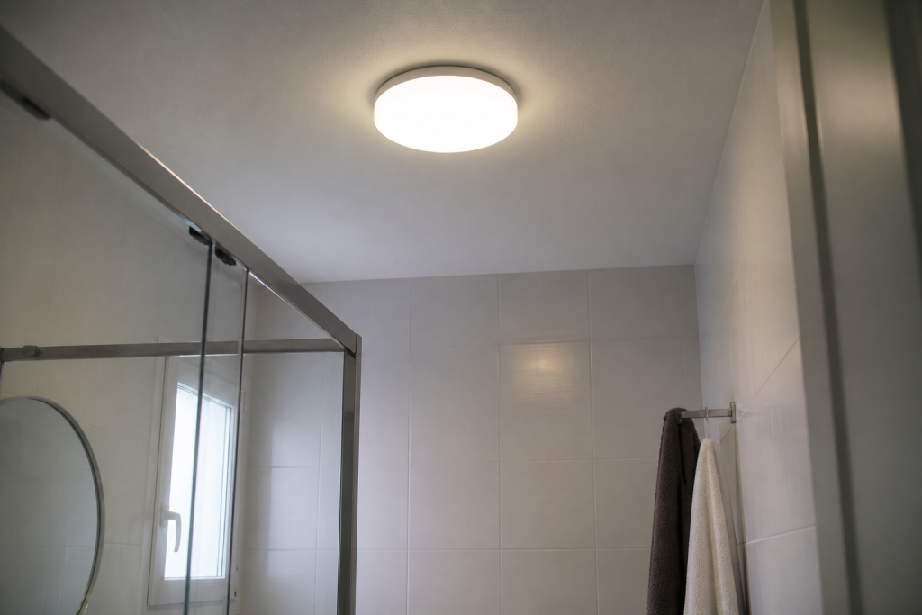 Plafonnier eclairant salle de bain avec carrelage clair