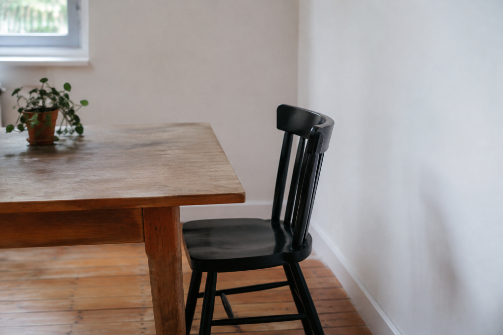 Table en bois avec chaise noire contre le mur